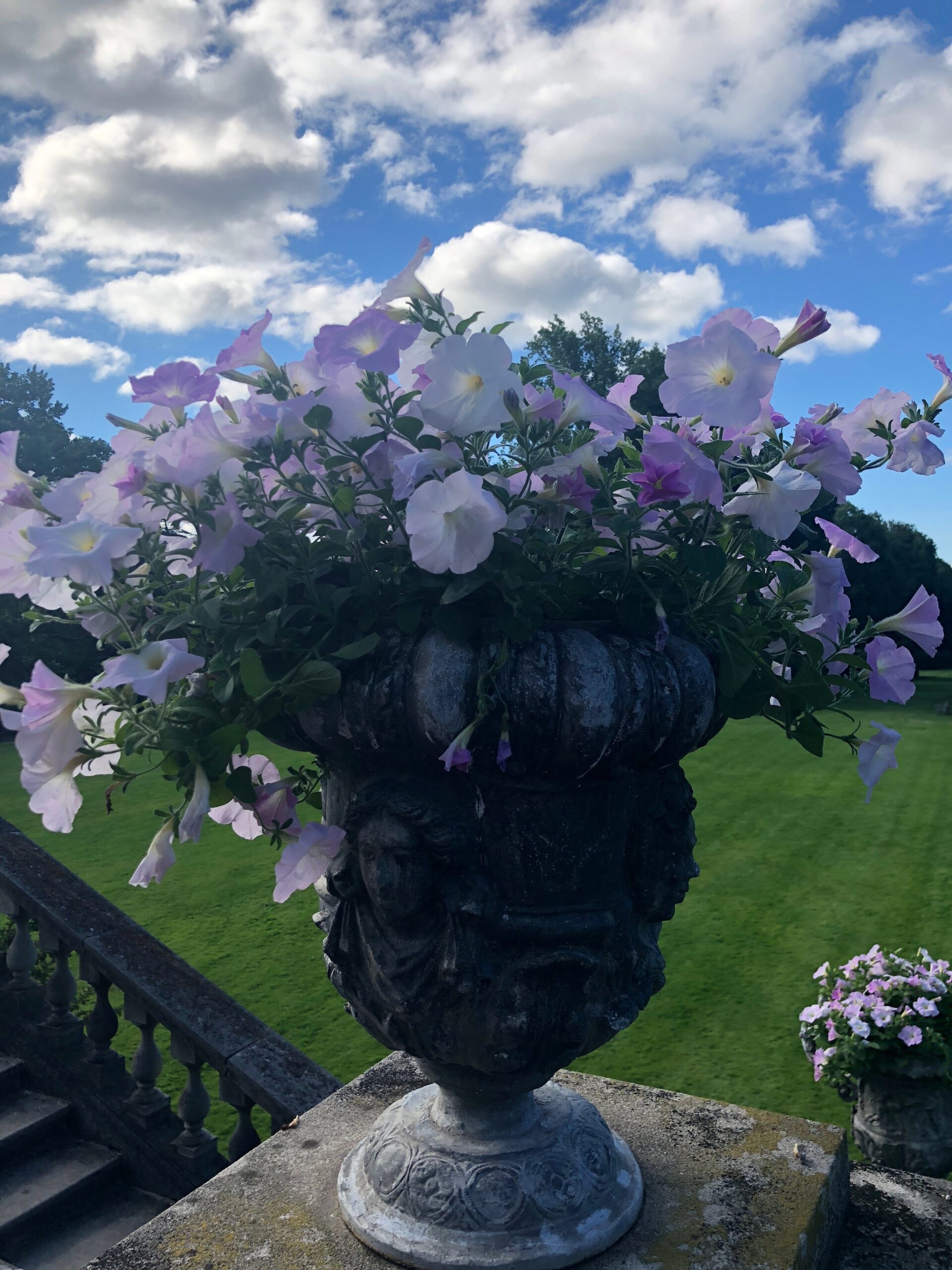 Urn of light purple peonies sitting on a staircase