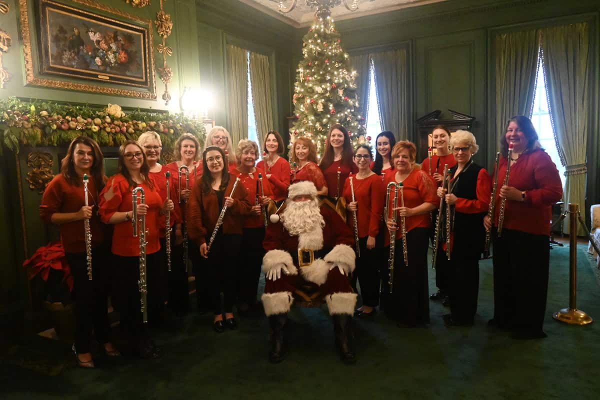 members of the flute choir posing with santa claus